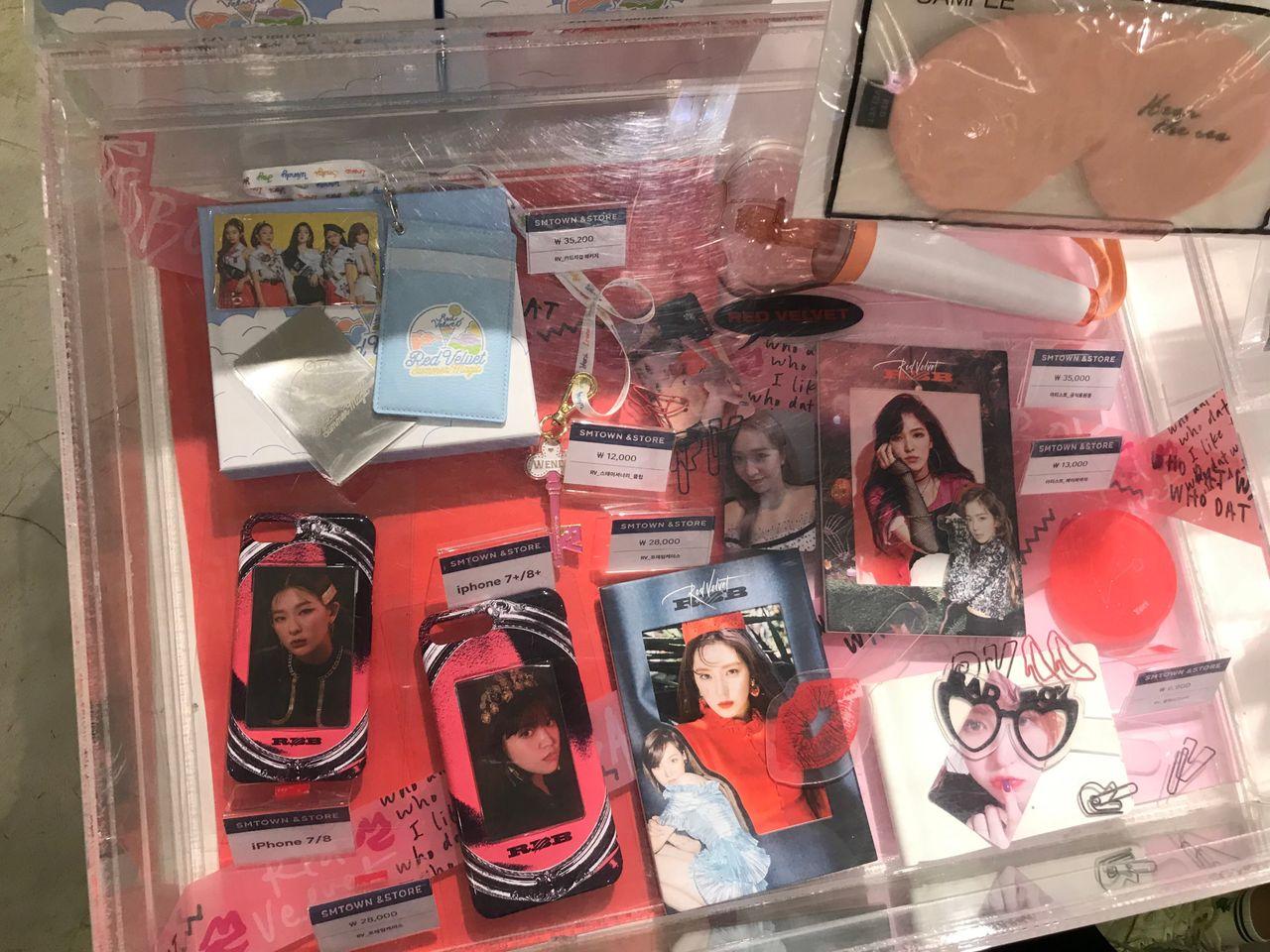 Red Velvet相關商品，包括特製手機殼和紀念品，在SMTOWN商店裡整齊排列。